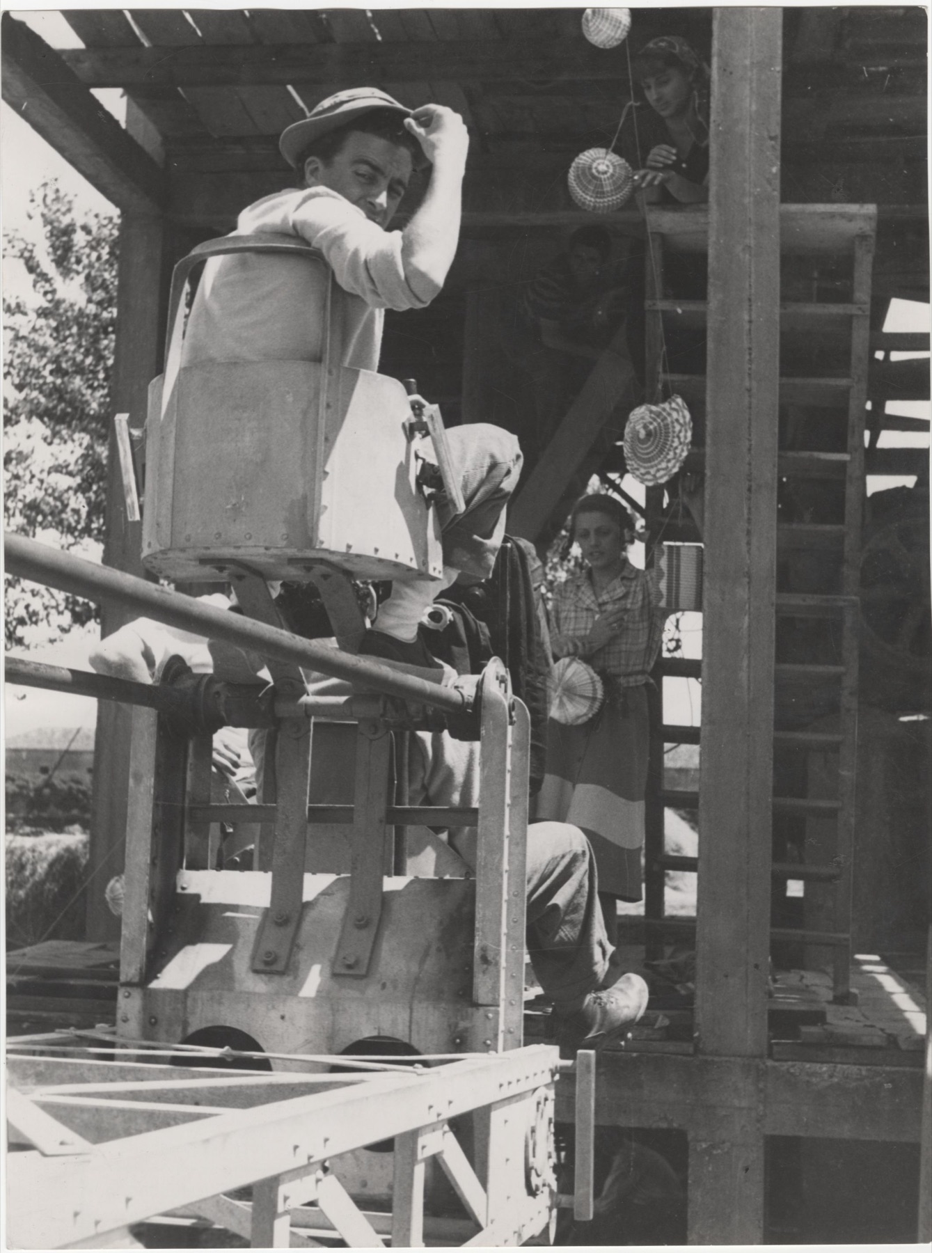 Zwart-witfoto van een filmset in 1949: een camera op een kraan, crew en toeschouwers bij de opnames van Riso amaro.
